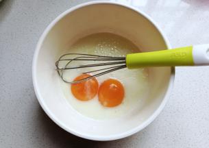 先将玉米油和牛奶放入容器中拌均匀，再加入蛋黄继续搅拌均匀；