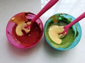 然后把蛋黄糊分成两份加入红曲粉溶液和大麦青汁粉溶液中拌均匀；