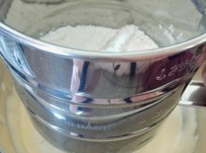 全蛋液中，分三次筛入低筋粉，每一次都要用刮刀翻拌均匀，注意不要打圈，用炒菜一样的方式拌