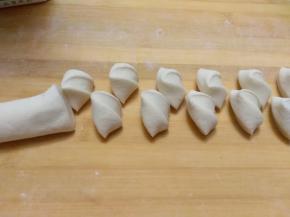 用手左右交替翻动长条面，另一手用刀切好大小均匀的剂子