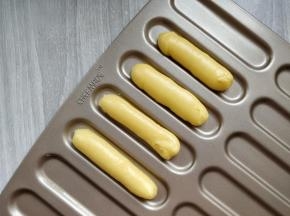 在学厨闪电泡芙模上挤出均匀的条。因为后期要做成小猫的形象，不必要太长，所以没有完全按照模具长度。