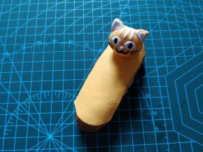 取一块翻糖皮，擀成薄片，根据泡芙的形状，切成两头半圆的长条状，蘸少许热水，粘合在泡芙上。