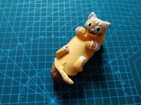 捏出小猫的四肢，粘合在底座上，捏出尾巴，一个肚皮朝上的小猫就做好了。
