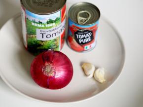 4.发面的时间来炒番茄酱，准备好炒酱料的材料：西红柿罐头200克、西红柿膏20克、洋葱50克、大蒜2瓣
