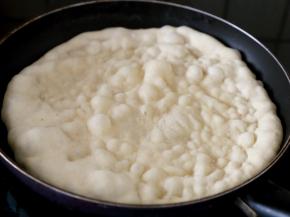 15.热锅热油，下饼坯，盖锅煎烙到鼓起大量泡泡，表面没有生面时翻面。
注：油多就是煎炸，比较较油腻；油少就是煎烙，两种都可以，我选择的是煎烙。
