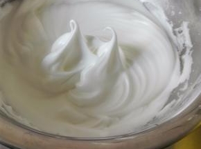 蛋清中滴入几滴柠檬汁，用电动打蛋器低速打至泡沫密集，一次性加入细砂糖，用打蛋器的中速，打至图中的样子，大弯勾，也就是湿性发泡