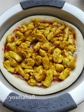 披萨面饼上放炒好的鸡胸肉，铺上蘑菇片