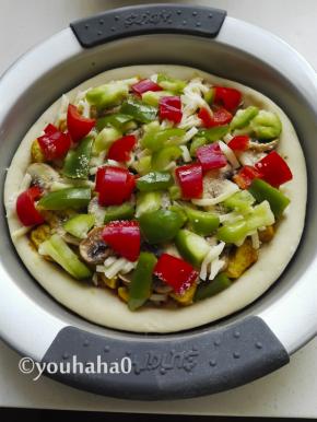 再撒一层芝士粉，撒上少许的奶酪丝，放上青红椒块