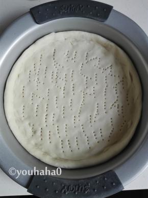 咖喱鸡肉披萨的做法步骤33.取出发酵好的面团，揉匀擀开放入披萨盘中，盘子四周稍高一点，醒发20分钟左右，饼皮表面用叉子扎眼