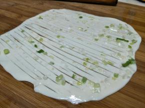 再刷上葱花，用刀把面皮中间切开，不要切断。