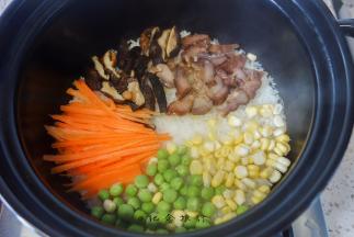 6、	胡萝卜丝、青豆、玉米粒摆在米饭上，中间留出一个洞