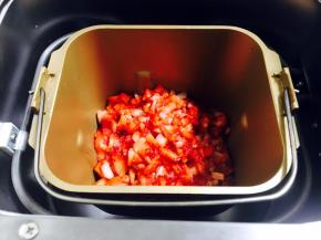 把草莓粒放入面包机的桶里。