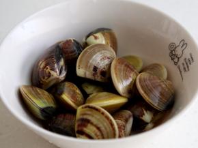 2.将吐净沙的蛤蜊壳清洗干净。
