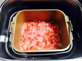 将搅拌好的辅助食材倒入盛有草莓的面包机桶里。