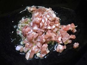 锅内放油烧热，放入肉丁翻炒