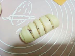 从面皮另一端卷起，最后切成条状的部分位于正面，把下面开口处捏紧