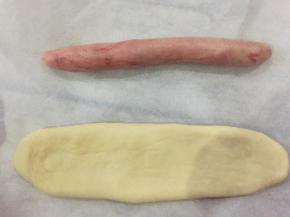 取一个红色面团和一个原色面团，红色面团揉成小圆棍形，原色面团擀成牛舌状。