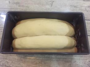 放入烤箱中层40度发酵50分钟，记得放一碗水哦，天气冷不放水会干皮的。

发酵好的样子是这样子的，也可以再发大一点，我是喜欢这样差不多满模，然后盖上盖子，不预热烤箱直接上下火150度32分钟。因为烤箱在升温的过程中面包会再次发酵的。