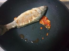 翻面煎另一面，两面都煎成金黄色。煎好后放入切碎的郫县豆瓣酱，放半勺料酒