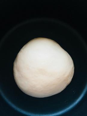 将揉好的面团放入容器，覆盖保鲜膜，进行第一次发酵，时间30分钟。