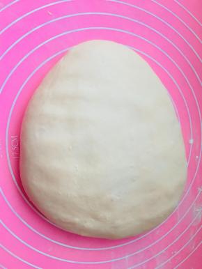 第一次发酵好的面团，放在硅胶垫上，用手拍遍它，拍掉气泡。平均分成3份，3份的话长度较长。烤箱限制的话，可以分成6份。