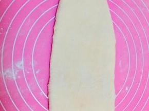 第二次发酵好的面团，擀成牛舌型，拍掉气泡。
