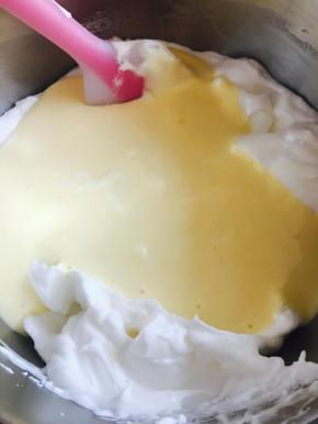 再将搅拌均匀的蛋黄糊。全部倒回蛋白中。翻拌，切拌。不可画圈