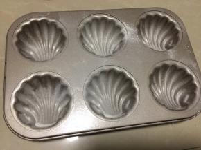 玛德琳烤盘撒入面粉，以免黏模具