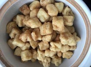 油豆腐用热水泡一下，沥干水份，到入煲内