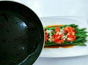 起锅热油，放入花椒粒爆香，趁油热浇在蒜末、彩椒上。听的一声“嗞啦”响，蒜香飘出，故名“响油”芦笋。