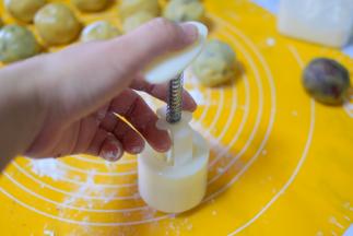 再把上一步包好的月饼生胚放在模具中