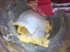 将软化的黄油用刮刀搅拌均匀后倒入白砂糖用打蛋器搅拌均匀