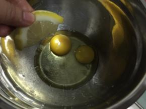 鸡蛋磕入碗中挤入柠檬汁