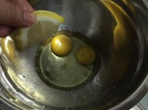 鸡蛋磕入碗中挤入柠檬汁