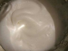 接着再用电动打蛋器继续高速打发，当蛋清泡沫消失，变得细腻顺滑的时候就可以再加入另外的三分之一糖粉