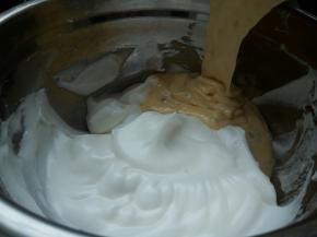 将拌匀的面糊倒入剩余的蛋白里，再次翻拌均匀即成戚风蛋糕面糊。倒入模具，振出大气泡