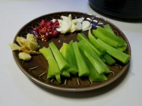 配菜切成条
大蒜切成片
然后准备辣椒，葱，姜。