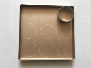 准备做泡芙：烤盘涂抹上黄油，圆形模具沾上面粉在烤盘上印出印子