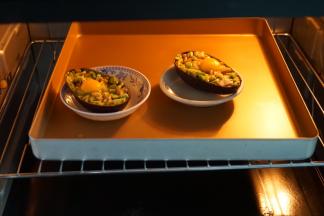 然后将牛油果放入味碟中固定，再放入烤盘中