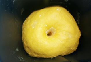 面粉的吸水性不同，请根据实际情况调整南瓜泥的用量，揉成一个柔软的面团。面团揉好以后，放在面包机里，盖上湿布，室温下发酵至2倍大，手指沾面粉轻轻插入面团里，拔出手之后孔洞不会塌陷也不会回缩，就表示发酵好了。