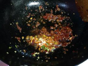 炒出红油后加入一半的姜，蒜碎炒出香味