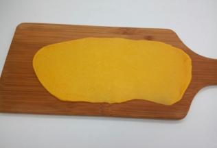 将发酵好的面团放在案板上，排出面团内部的气体，分成10小份，盖上保鲜膜醒发15分钟案板上撒一些面粉防粘，将一个醒发好的小面团压扁，并用擀面杖擀成长条形