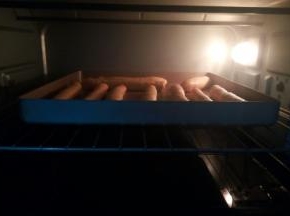 从侧面卷起来，收口，放不粘烤盘烤箱开启发酵键，上下火35度，最下面的烤盘放一点热水，保持湿度，放面包棒再次发酵变大