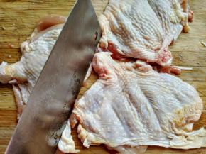 用刀背将鸡腿肉敲打，并用牙签在鸡肉上扎小孔，方便入味。