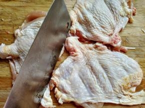 用刀背将鸡腿肉敲打，并用牙签在鸡肉上扎小孔，方便入味。