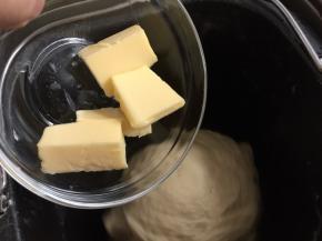 然后待面团揉至表面光滑时加入切小块的黄油