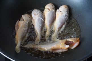 然后放入小黄鱼煎炸