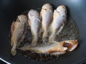 然后放入小黄鱼煎炸