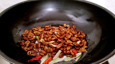 倒入蚕蛹，中火煸炒一会。