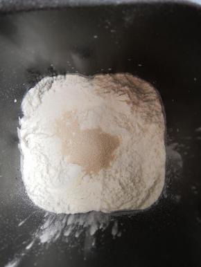 除黄油外，按照先液体再固体的顺序把所有材料放入面包机内，启动和面程序揉成光滑的面团